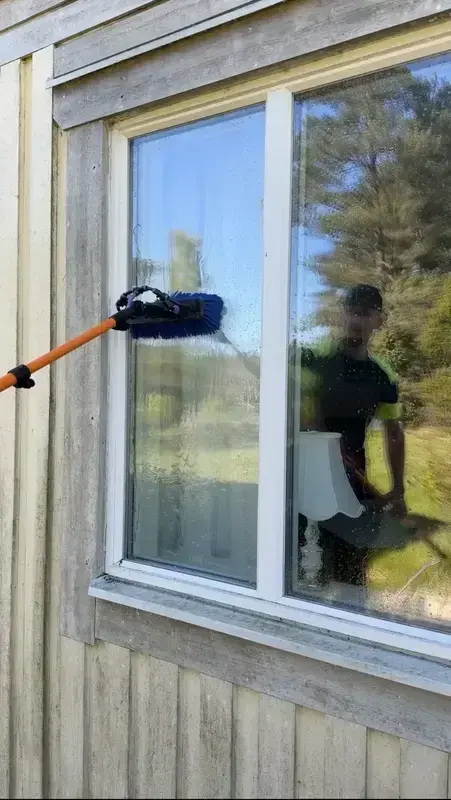 Fönsterputs av ett stort fönster med teleskopskaft