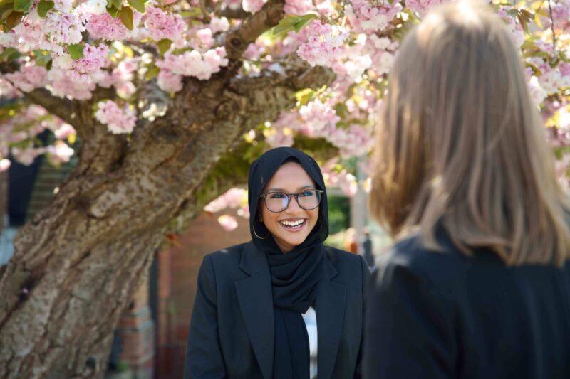 Chigwell school standing outside under flowering tree