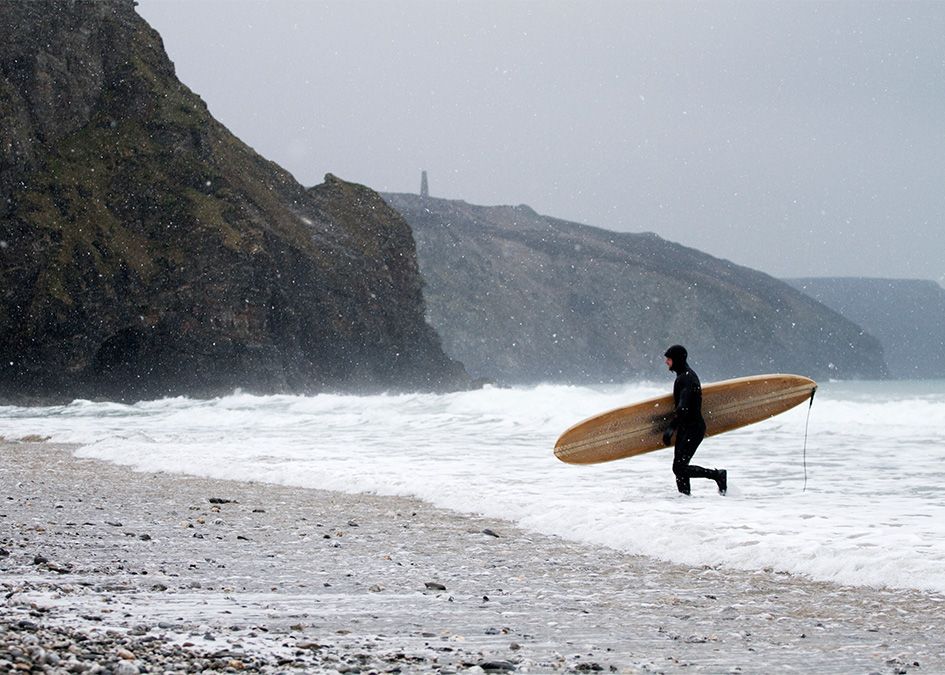 snow otter surfboard wooden beach cliffs
