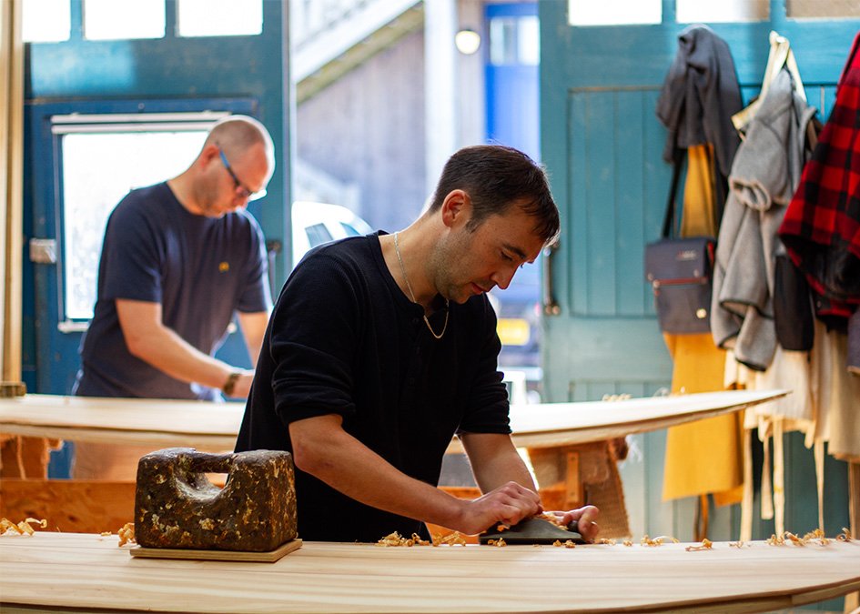 Otter wooden surfboard making workshop blue doors henry and matt portrait cornwall Henry planing