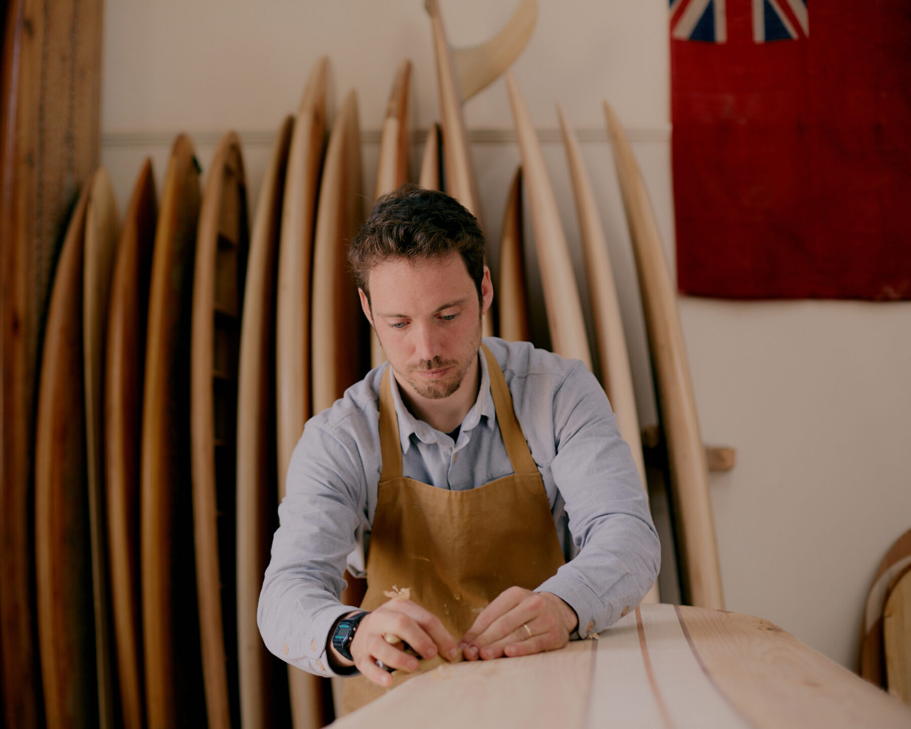 James Otter shaping wooden surfboard in workshop cornwall