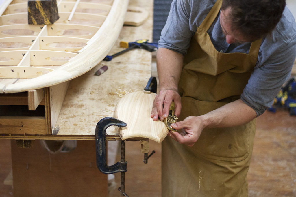 James otter hand making a wooden bodysurfing handplane