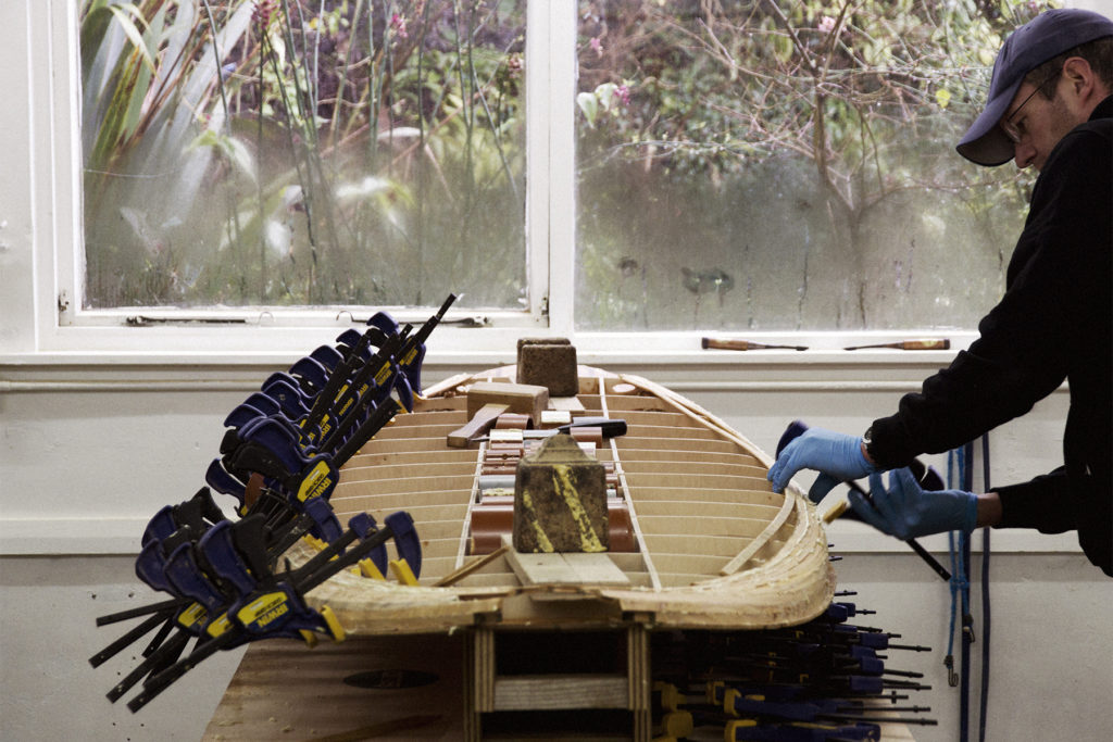 Allan Rorby building up the rail strips of his wooden paddle board in the otter surfboards workshop