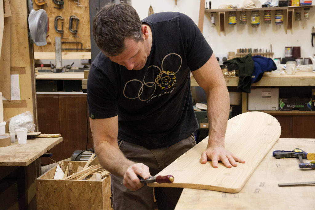Rasping the tail of an otter surfboards wooden bellyboard workshop course