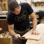 Rasping the tail of an otter surfboards wooden bellyboard workshop course
