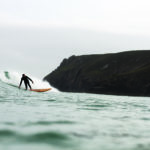 Chris bottom turning the Pier and Chapel Porth, Cornwall. Otter wooden surfboard