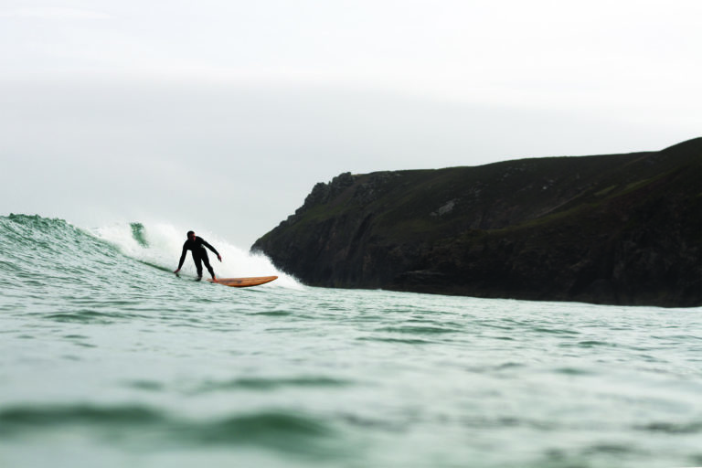 Chris bottom turning the Pier and Chapel Porth, Cornwall. Otter wooden surfboard