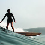 Rebecca Pepperell Surfing the Otter Surfboards Seasaw wooden longboard at Perranporth in Cornwall