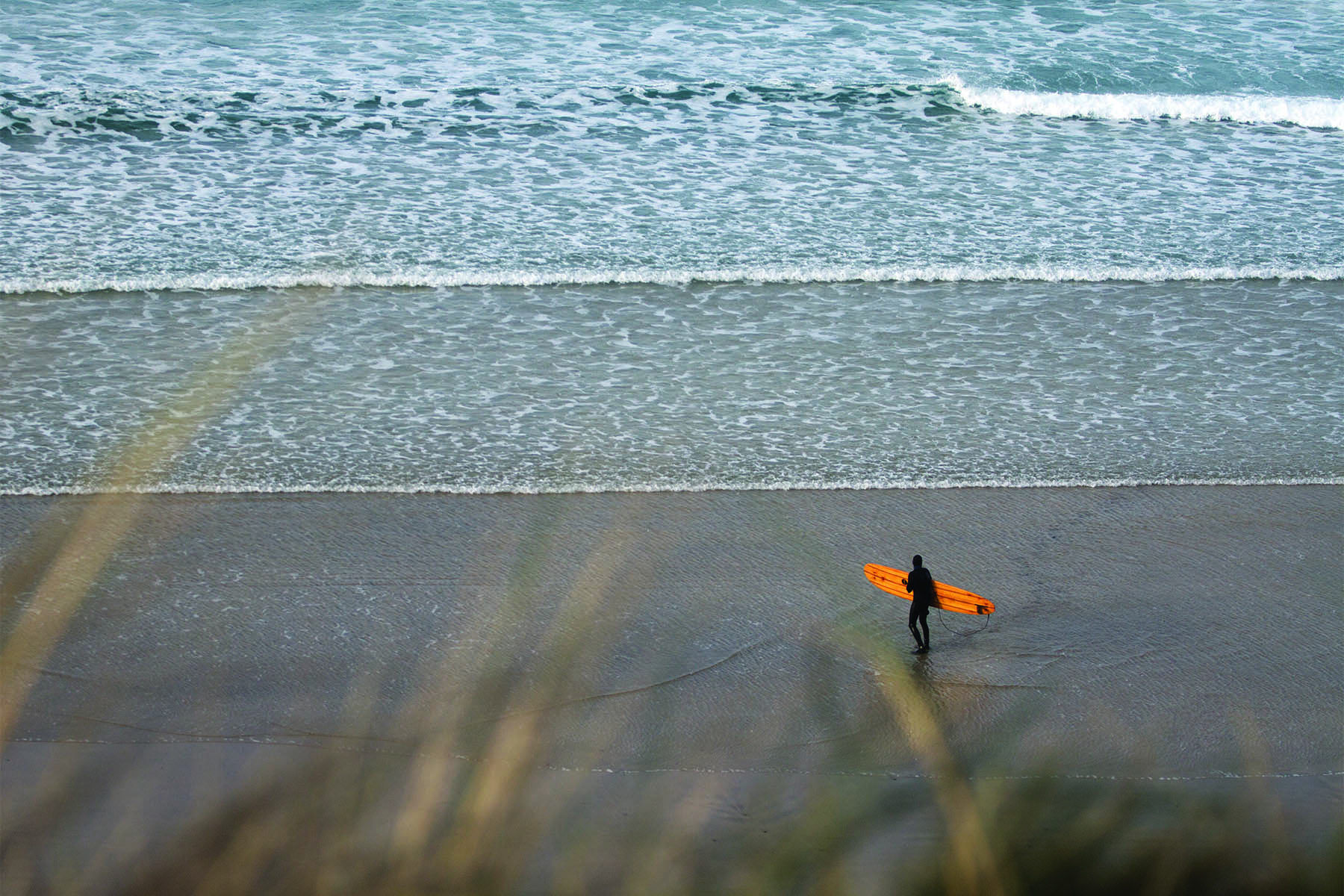 Mat Arney Looking back on the surf with the Otter Surfboards Pier wooden surfboard.