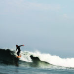 Chris Brunt hangs five noseride on a Seasaw Wooden Otter Surfboard in surf