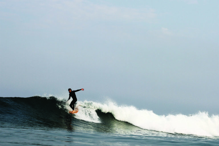 Chris Brunt hangs five noseride on a Seasaw Wooden Otter Surfboard in surf