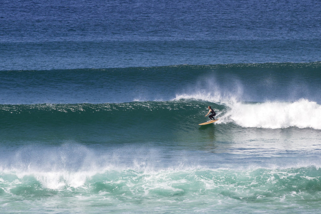 James Otter classic lines at Gwithian in the summer on his wooden surfboard Wicket in St Ives Bay