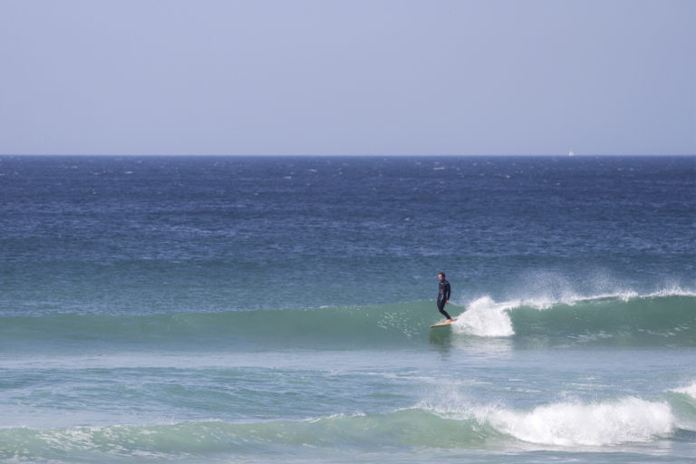 James Otter in trim on his wooden longboard Otter Surfboard Wicket at Porthtowan.