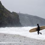 Otter Wooden Surfboard being carried out of the surf at Porthtowan in the snow. Wicket