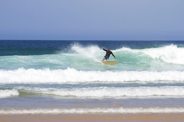 Dan Crockett leans into a turn at Gwithian in the summer in Cornwall on his Clipper Otter Wooden surfboard.