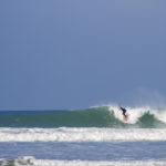 Sarah taking off on the otter surfboards wood burner Wooden surfboard at Gwithian, Cornwall shot from the beach