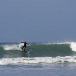 Sarah wrap around on the otter surfboards wood burner Wooden surfboard at Gwithian, Cornwall shot from the beach