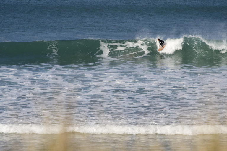 Sarah taking off on the otter surfboards wood burner Wooden surfboard at Gwithian, Cornwall