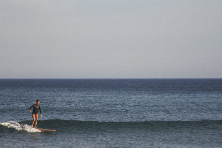 Sarah finding a ripple in the sun on the otter surfboards Pieces of Eight Wooden surfboard at Chapel Porth, Cornwall