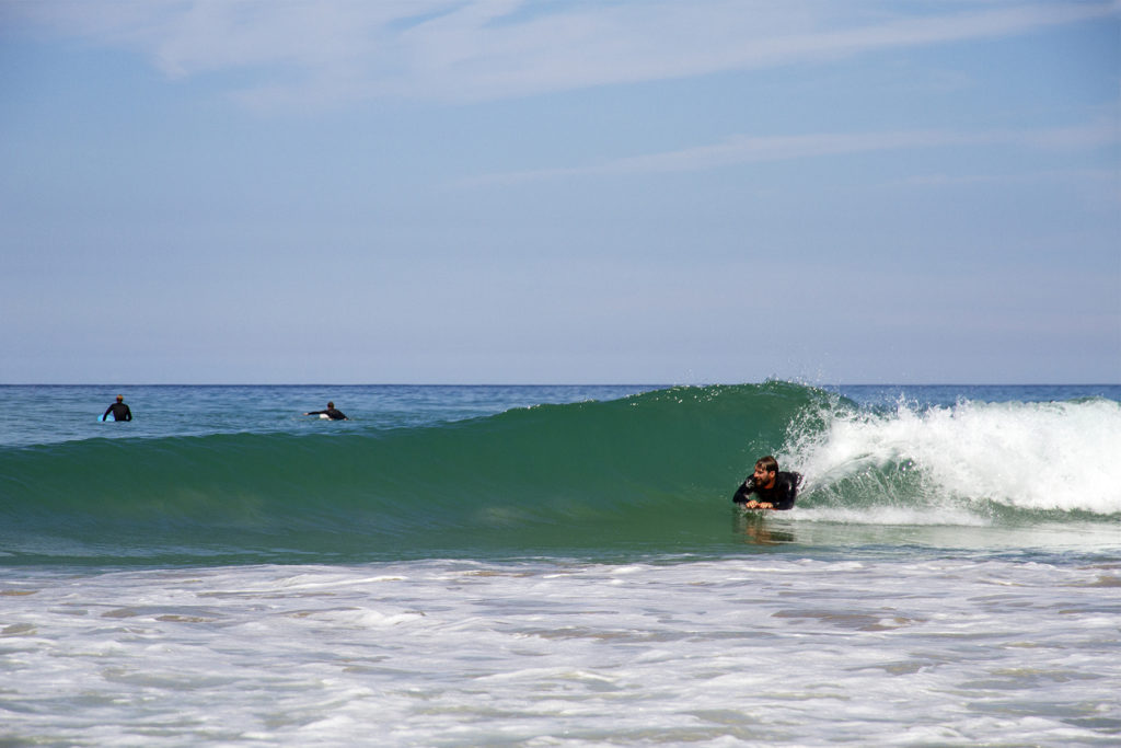 Tony catches a wave on his wooden otter bellyboard