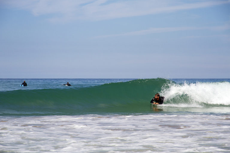 Tony catches a wave on his wooden otter bellyboard
