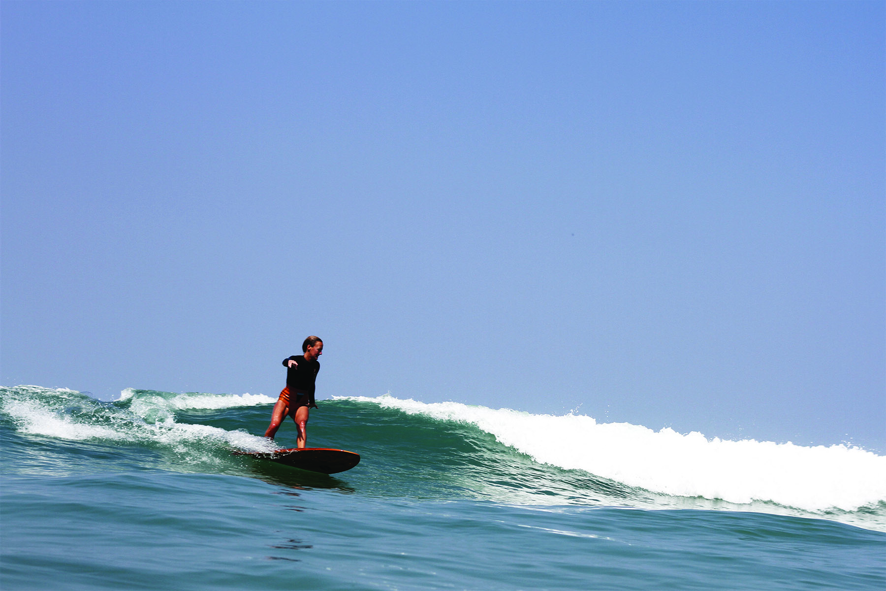 Sarah cuts back on a wave on the Woodburner at Chapel Porth, Cornwall. Otter Wooden surfboard