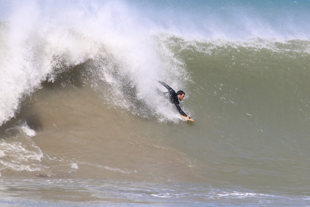 Chris drops into a big wave on his Otter Surfboards wooden handplane at St Agnes, Cornwall