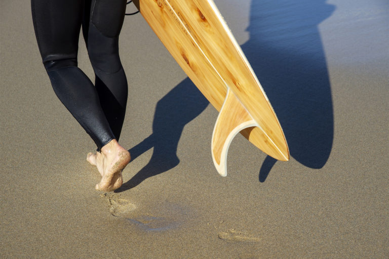 wooden surfboard and wooden fin james otter on the beach