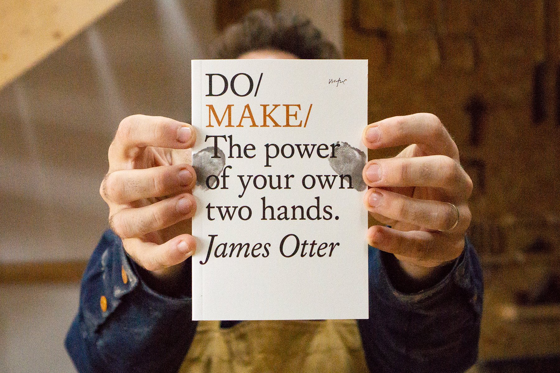 James Otter holding his book Do Make in the Otter Surfboards Workshop