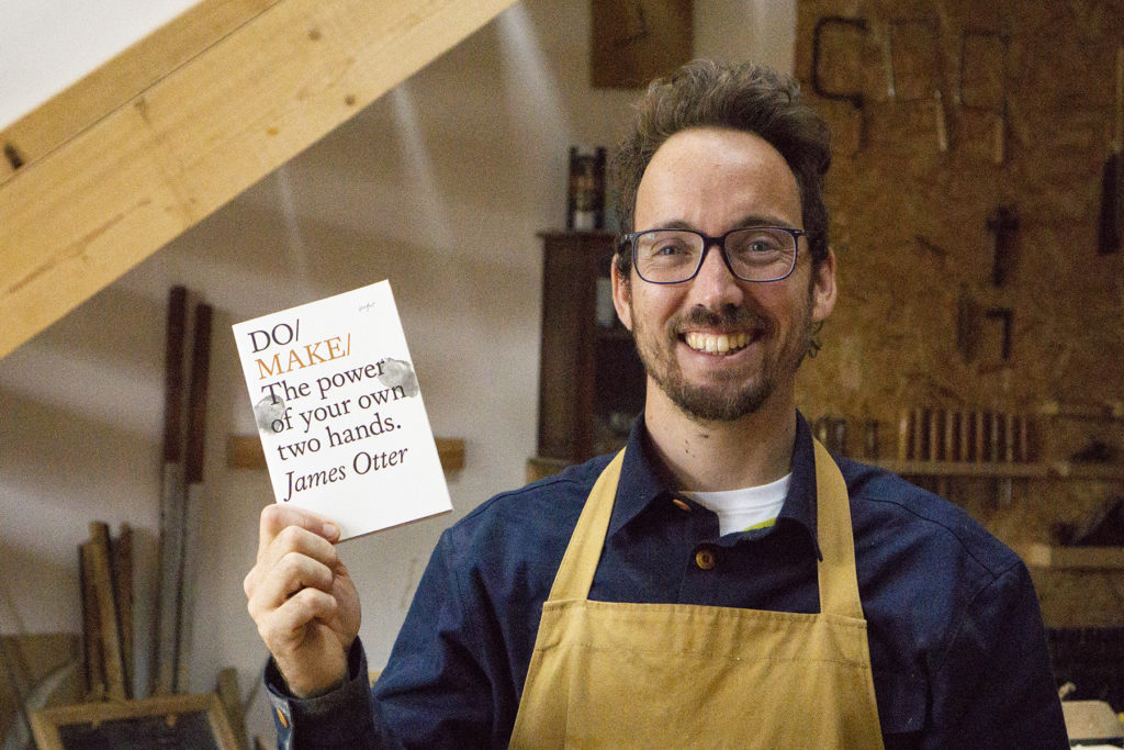 James Otter holding his book Do Make in the Otter Surfboards Workshop