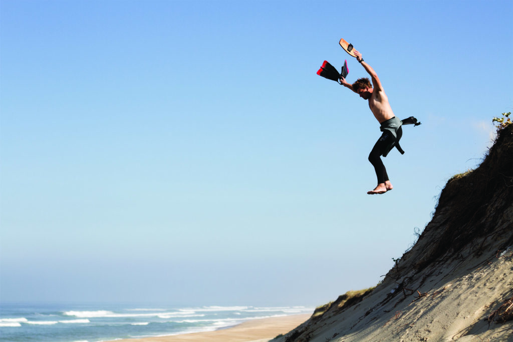 Harry jumps the dunes in france with his otter surfboards wooden bodysurfing handplane and his dafin swim fins