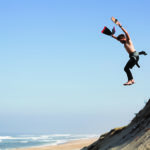 Harry jumps the dunes in france with his otter surfboards wooden bodysurfing handplane and his dafin swim fins