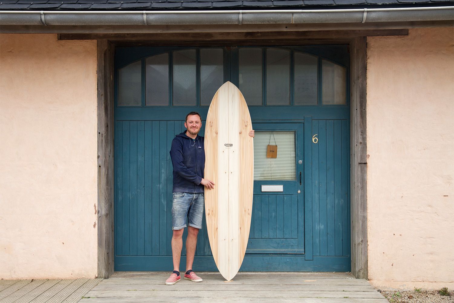 Otter wooden surfboard workshop blue doors