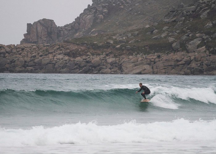 sean moffatt racing a wave on an otter surfboards wooden jetty