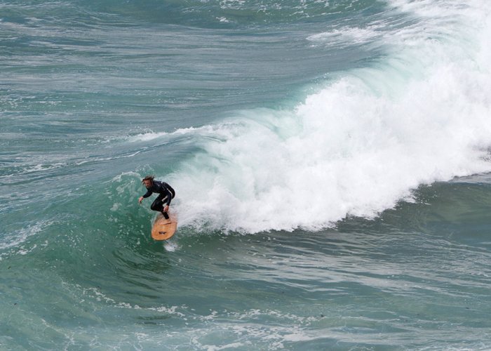 ben skinner on a wooden surfboard made for the national trust by james otter