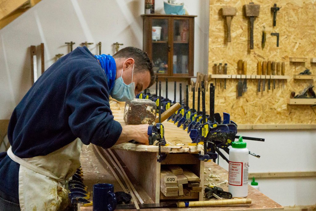 Harry, Chris and James Otter with wooden surfboards at the otter surfboards workshop in cornwall harry chiseling rails