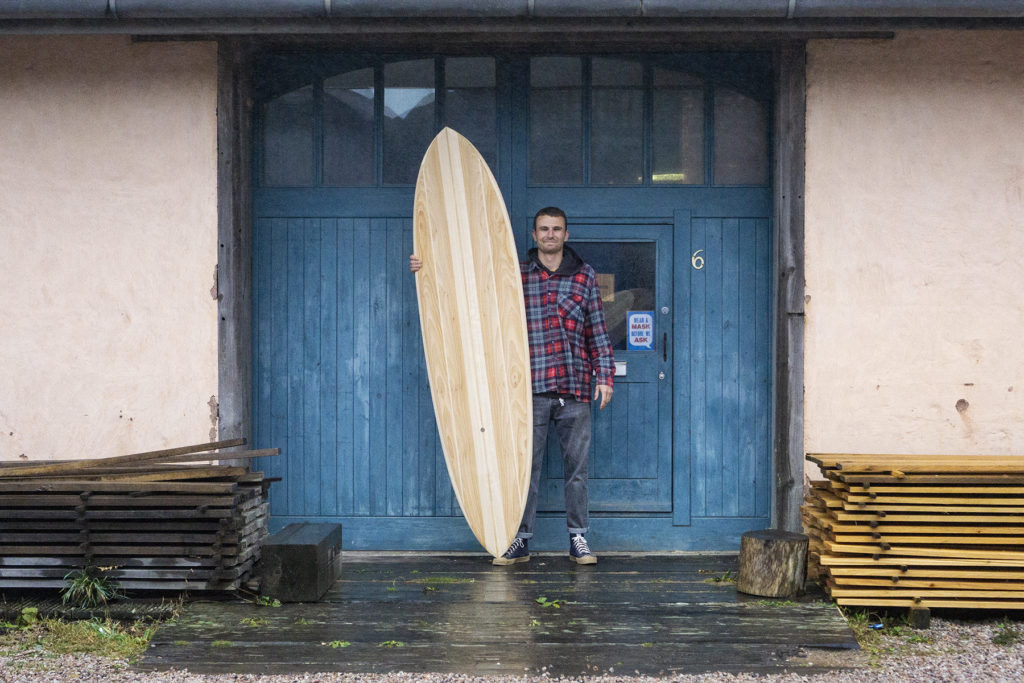 Harry, Chris and James Otter with wooden surfboards at the otter surfboards workshop in cornwall harry portrait