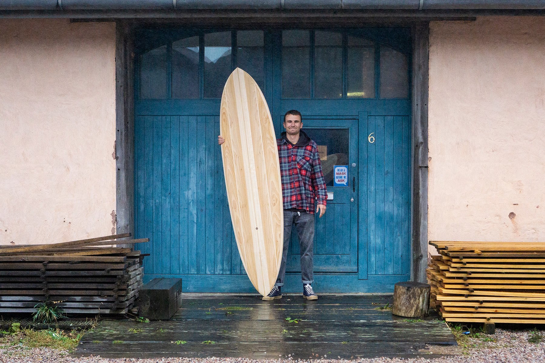 Harry, Chris and James Otter with wooden surfboards at the otter surfboards workshop in cornwall harry portrait