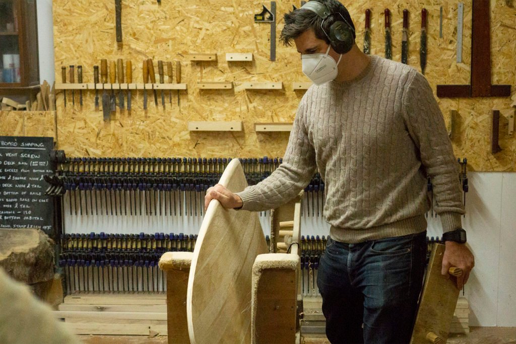 Harry, Chris and James Otter with wooden surfboards at the otter surfboards workshop in cornwall chris feeling rails