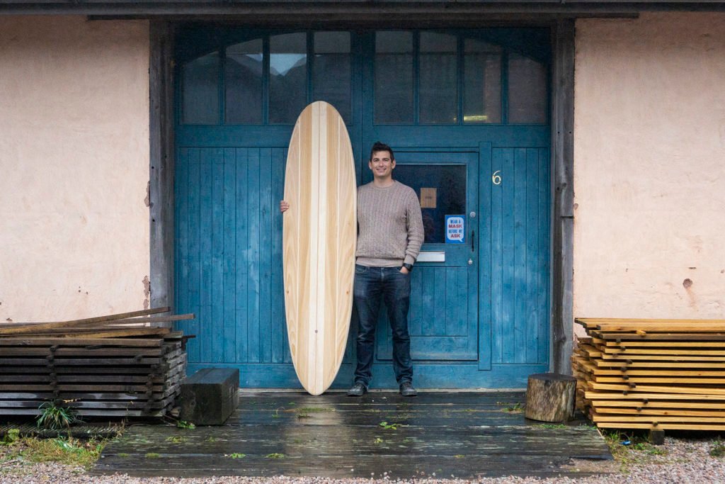 Harry, Chris and James Otter with wooden surfboards at the otter surfboards workshop in cornwall chris portrait