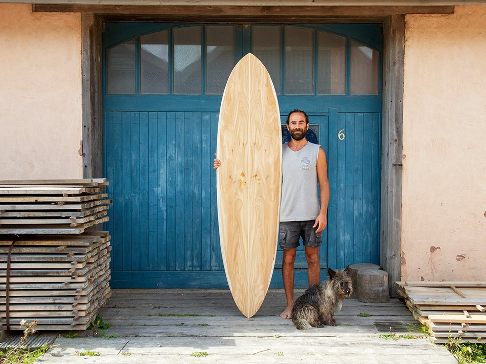 Otter Surfboards wooden surfboard making course with Ben and Marlow bens finished board blue doors