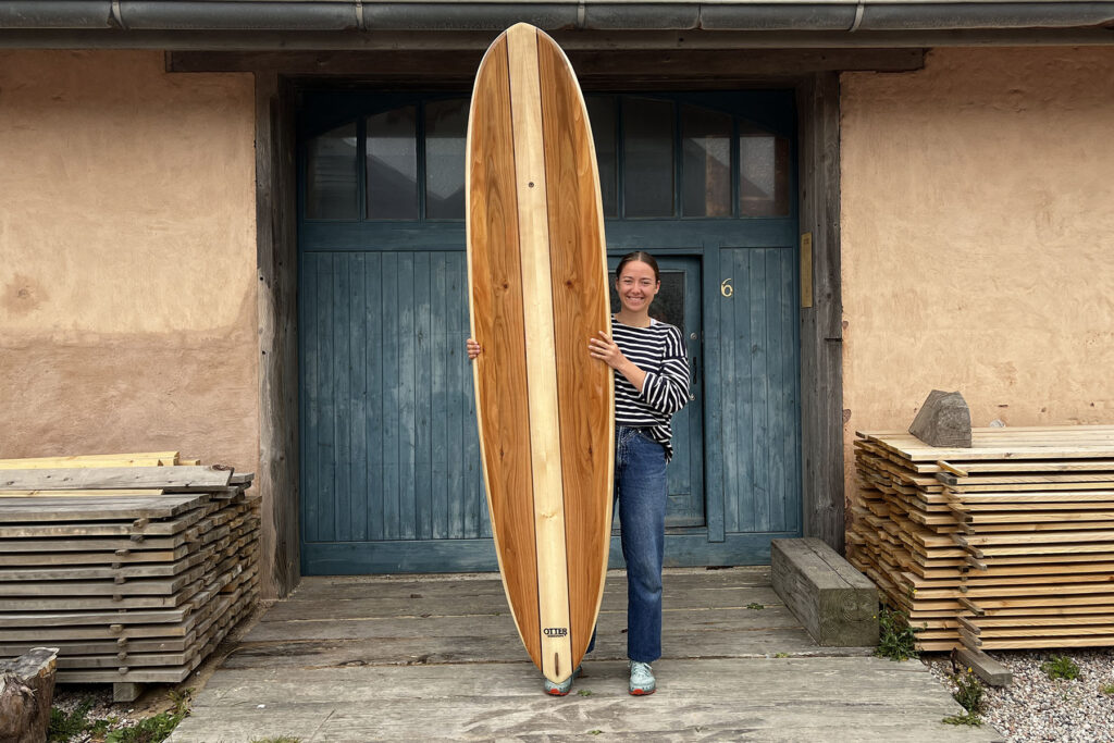 otter wooden surfboard blue door girl surfer