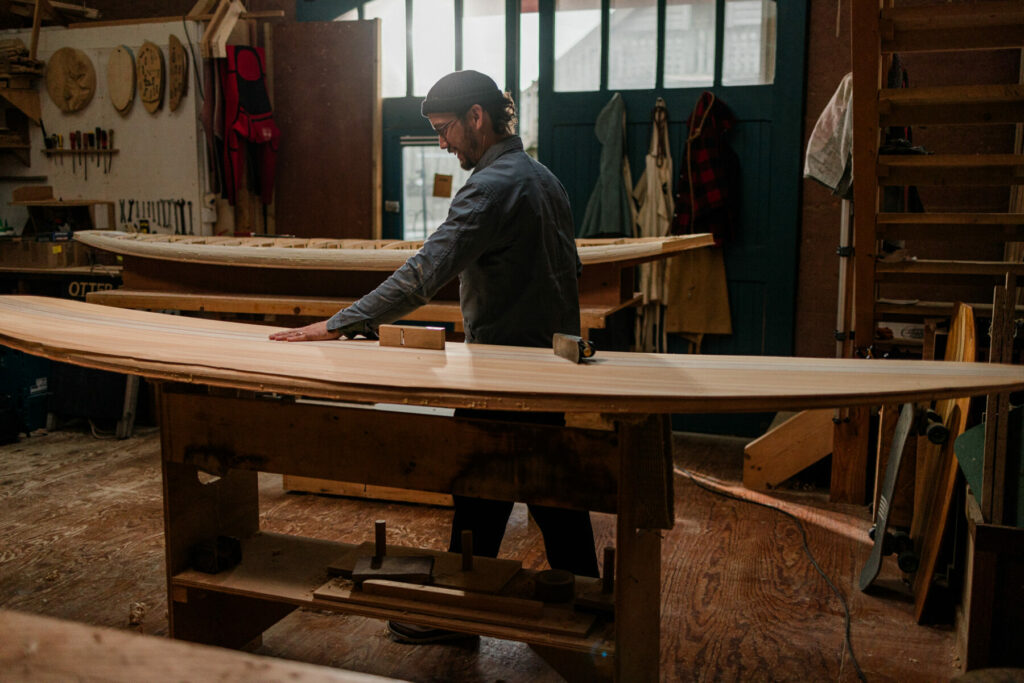 James Otter shaping wooden surfboard