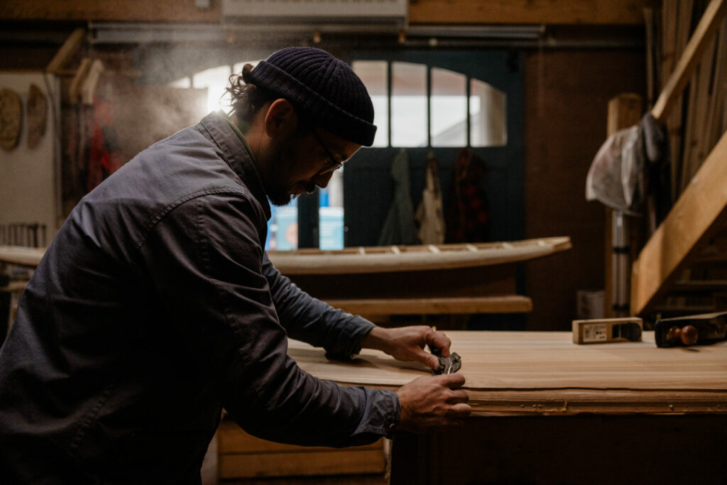 James Otter shaping wooden surfboard