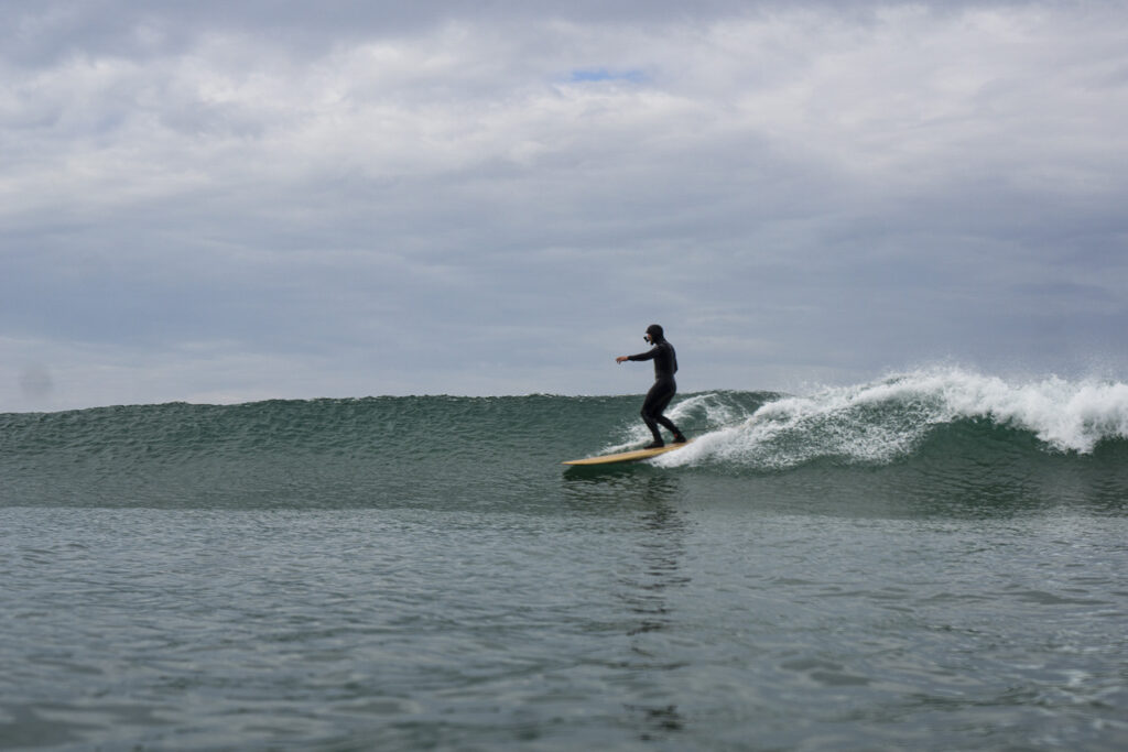 James Otter surfing a sustainable, hollow wooden surfboard