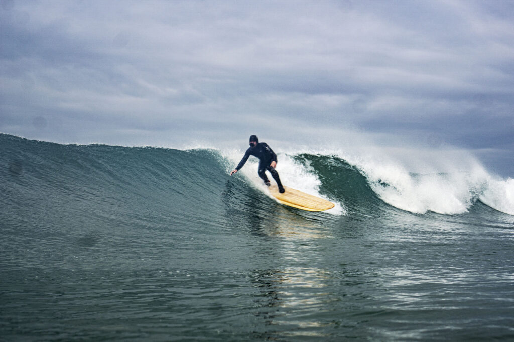 James Otter surfing a sustainable, hollow wooden surfboard