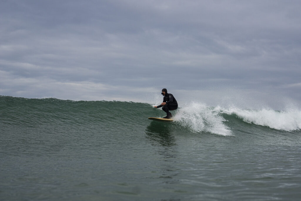 James Otter surfing a sustainable, hollow wooden surfboard