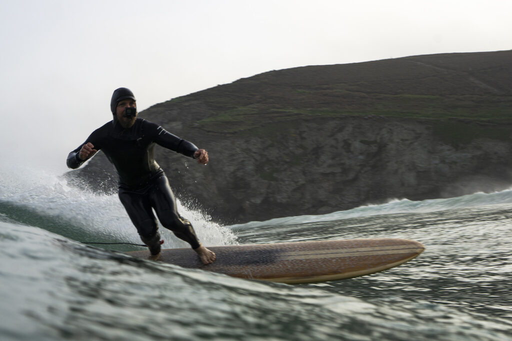 surfing a sustainable, hollow wooden surfboard by Otter Surfboards