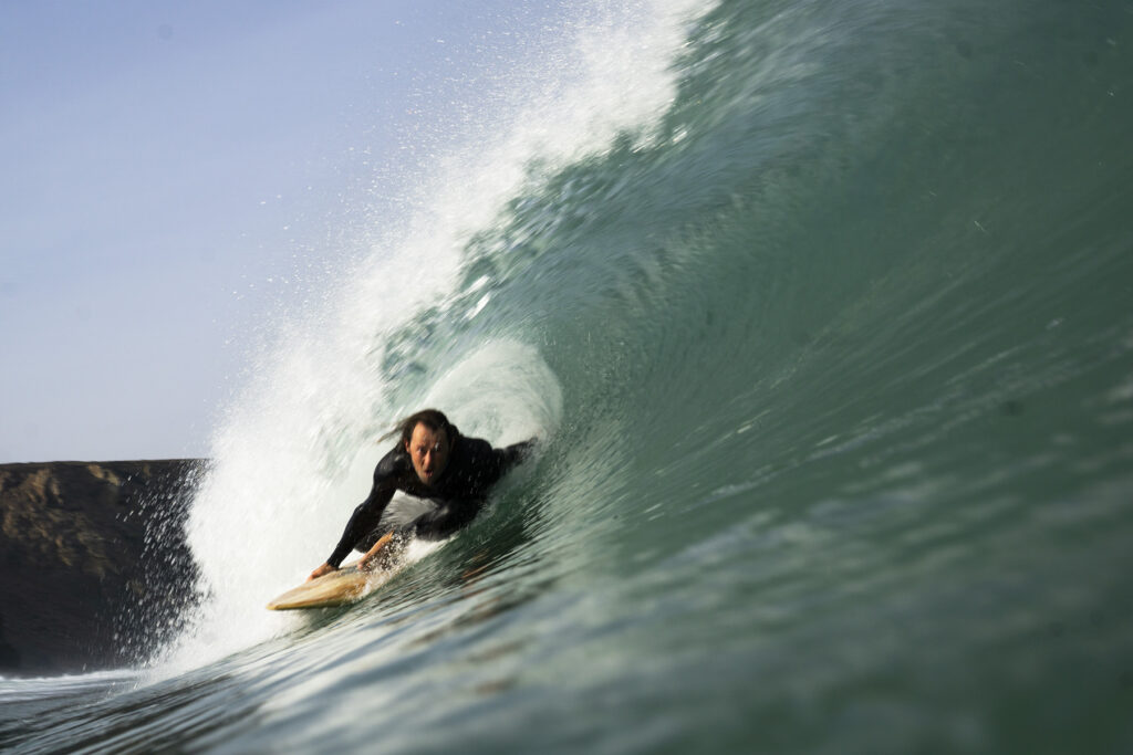 surfing a sustainable, hollow wooden surfboard by Otter Surfboards
