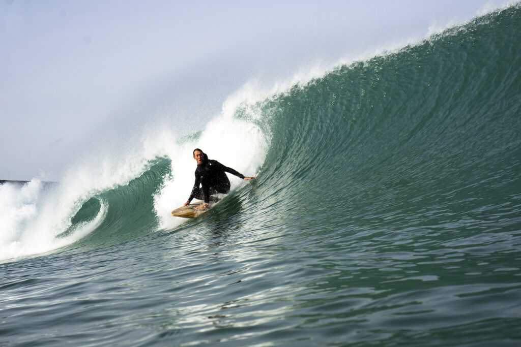 surfing a sustainable, hollow wooden surfboard by Otter Surfboards